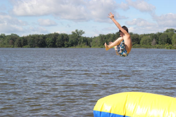 Camper doing a backflip into the water
